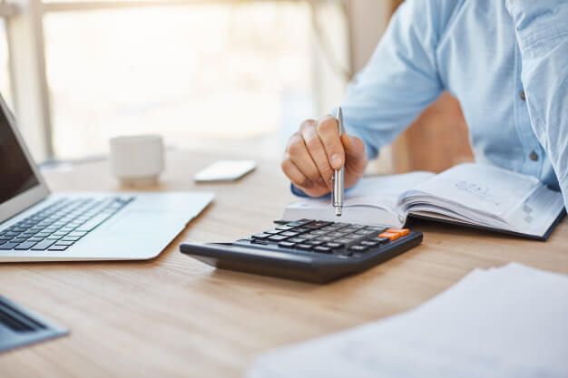 importância da contabilidade homem com papel e calculadora